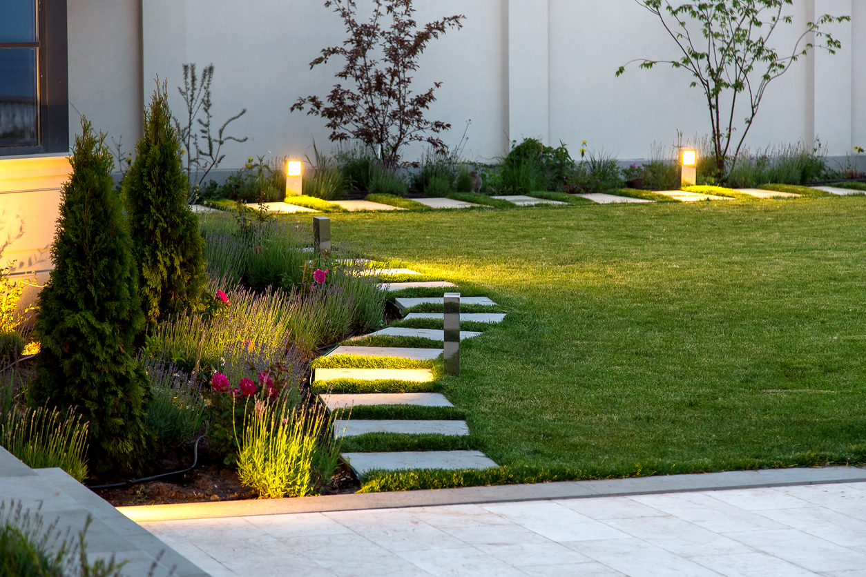 A grassy backyard with stone walkway.