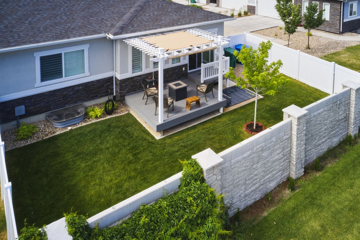 A aerial view of a backyard that is surrounded by a white fence.