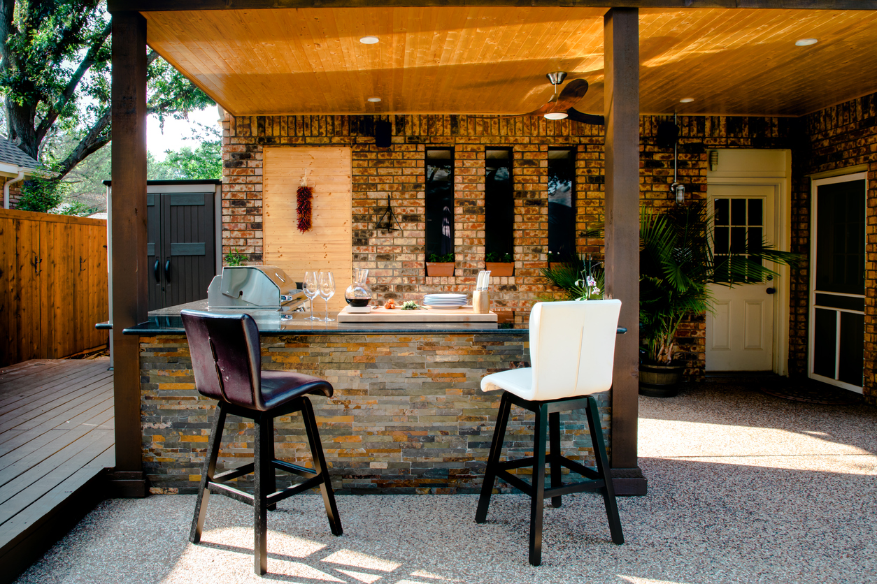 A large modern outdoor kitchen made with stone.