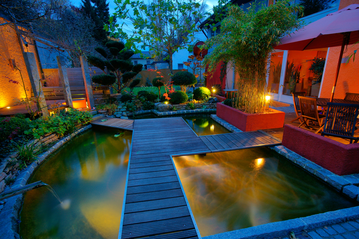 A backyard with wooden paths over a pond.