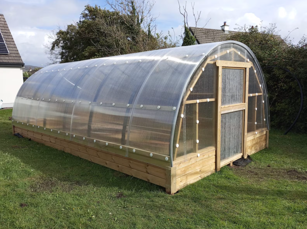 STORMIE polytunnel greenhouse hothouse on green grass.