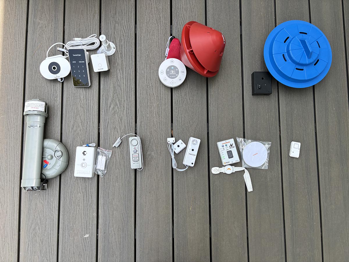 A group of the best pool alarms on a pool deck before testing.