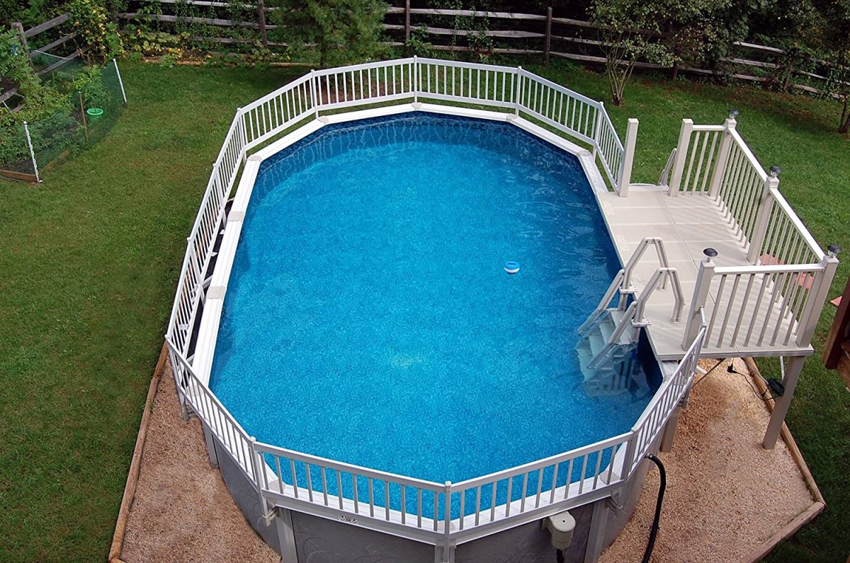 A large, above-ground pool with a fence around it and a set of stair leading into it.