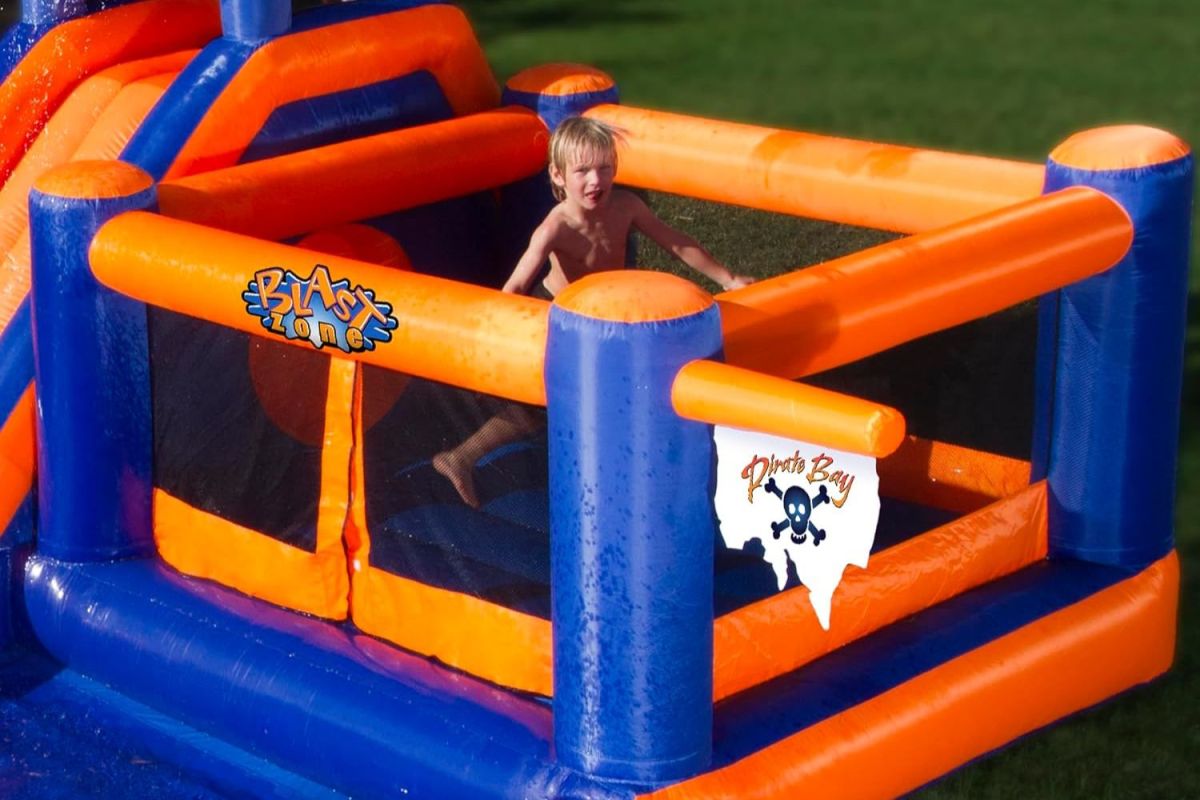 A young boy playing in an inflatable water slide
