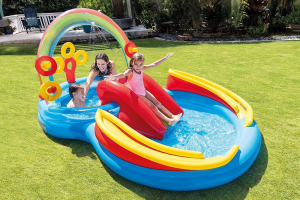 2 kids and an adult enjoying an inflatable water slide in the garden