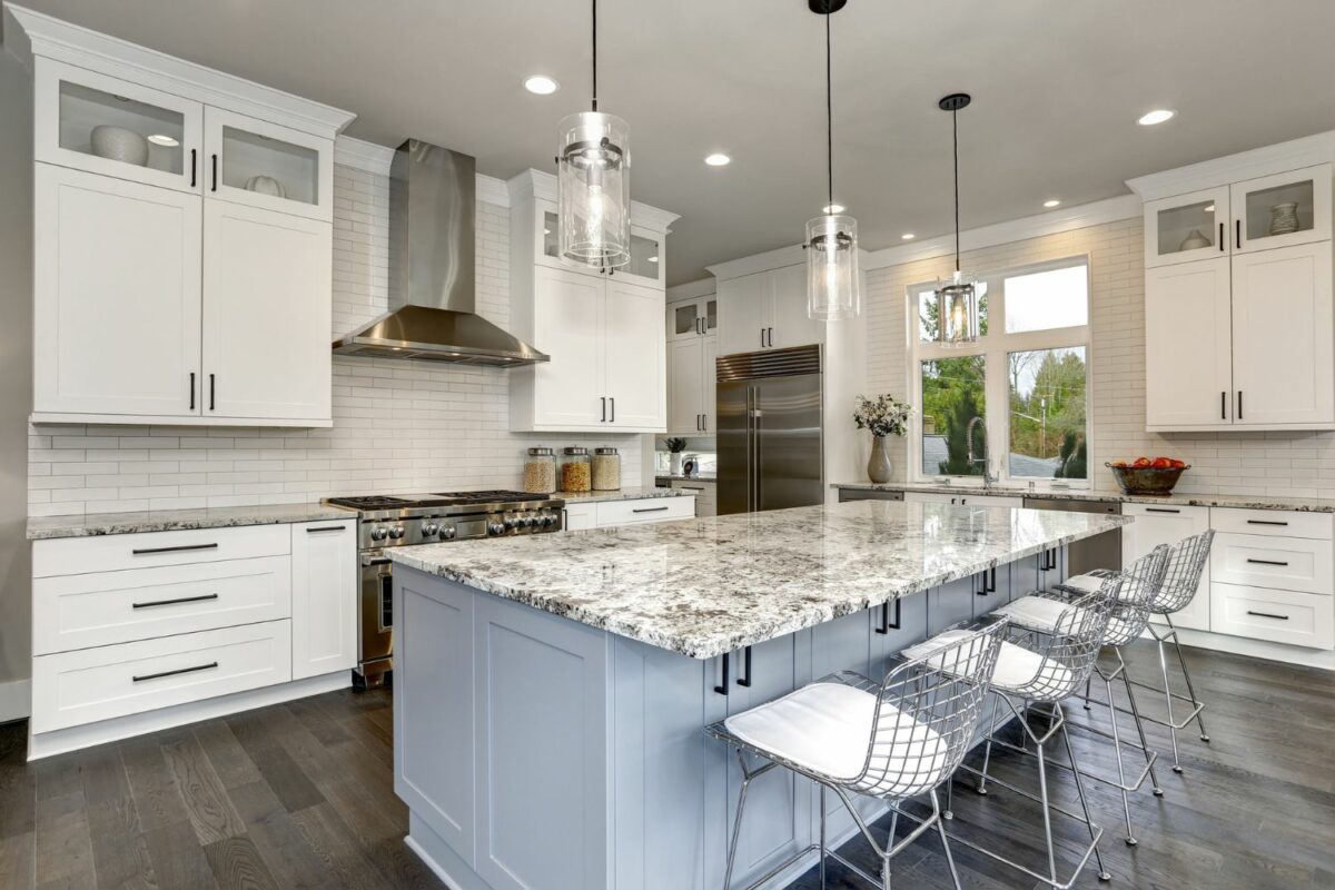 An open, modern-looking kitchen with clean white cabinets and quartz countertops.