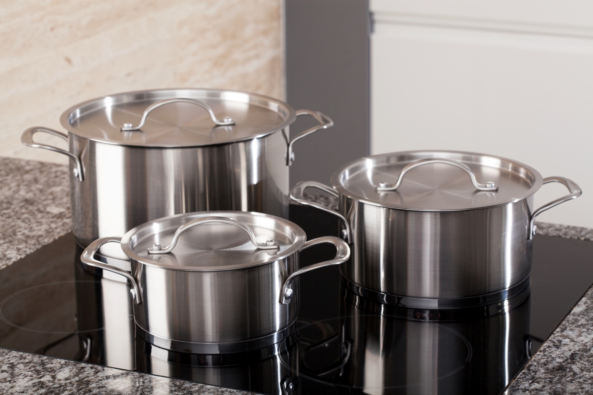 Three aluminum cooking pots on stove.