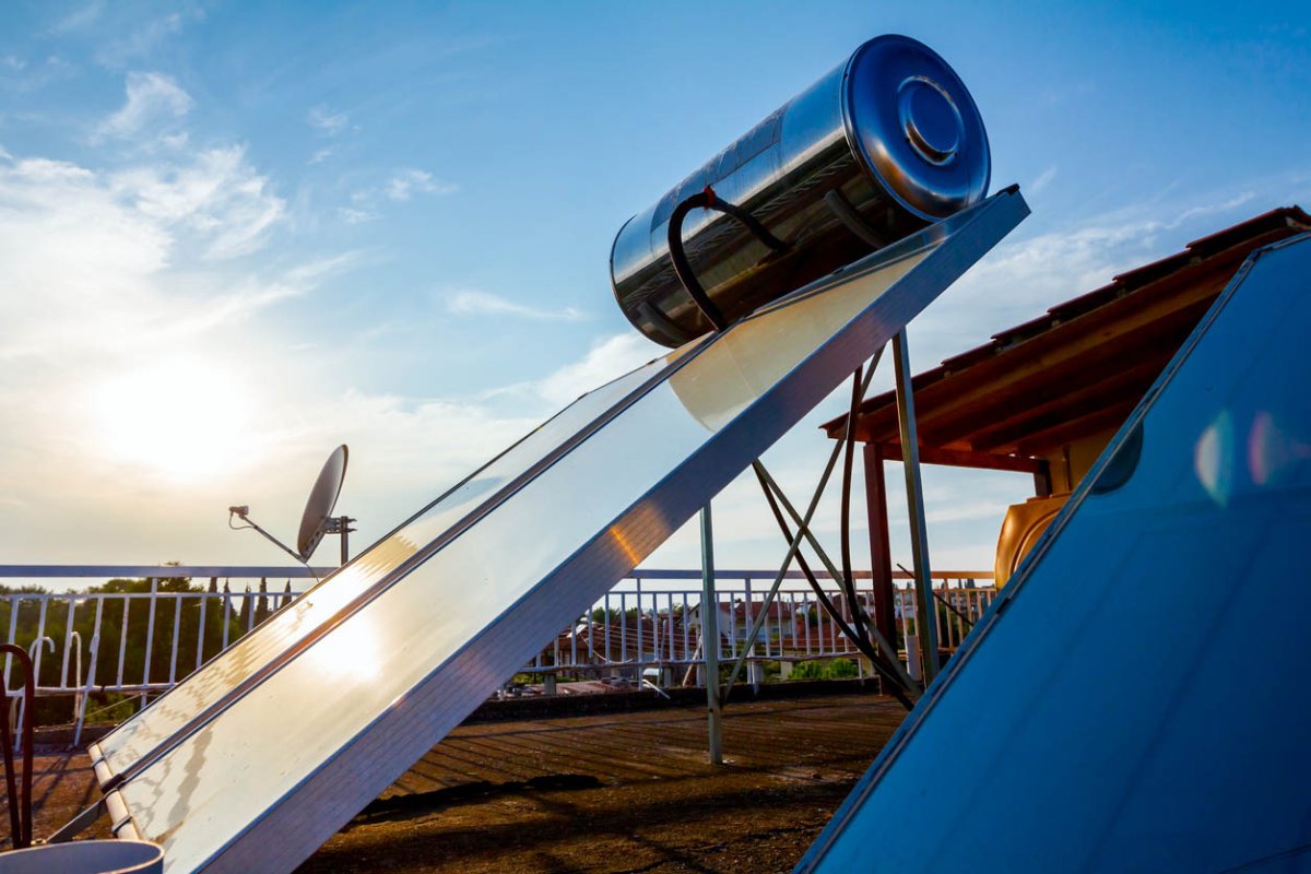 A solar pool heater on a roof with a satellite dish in the background.