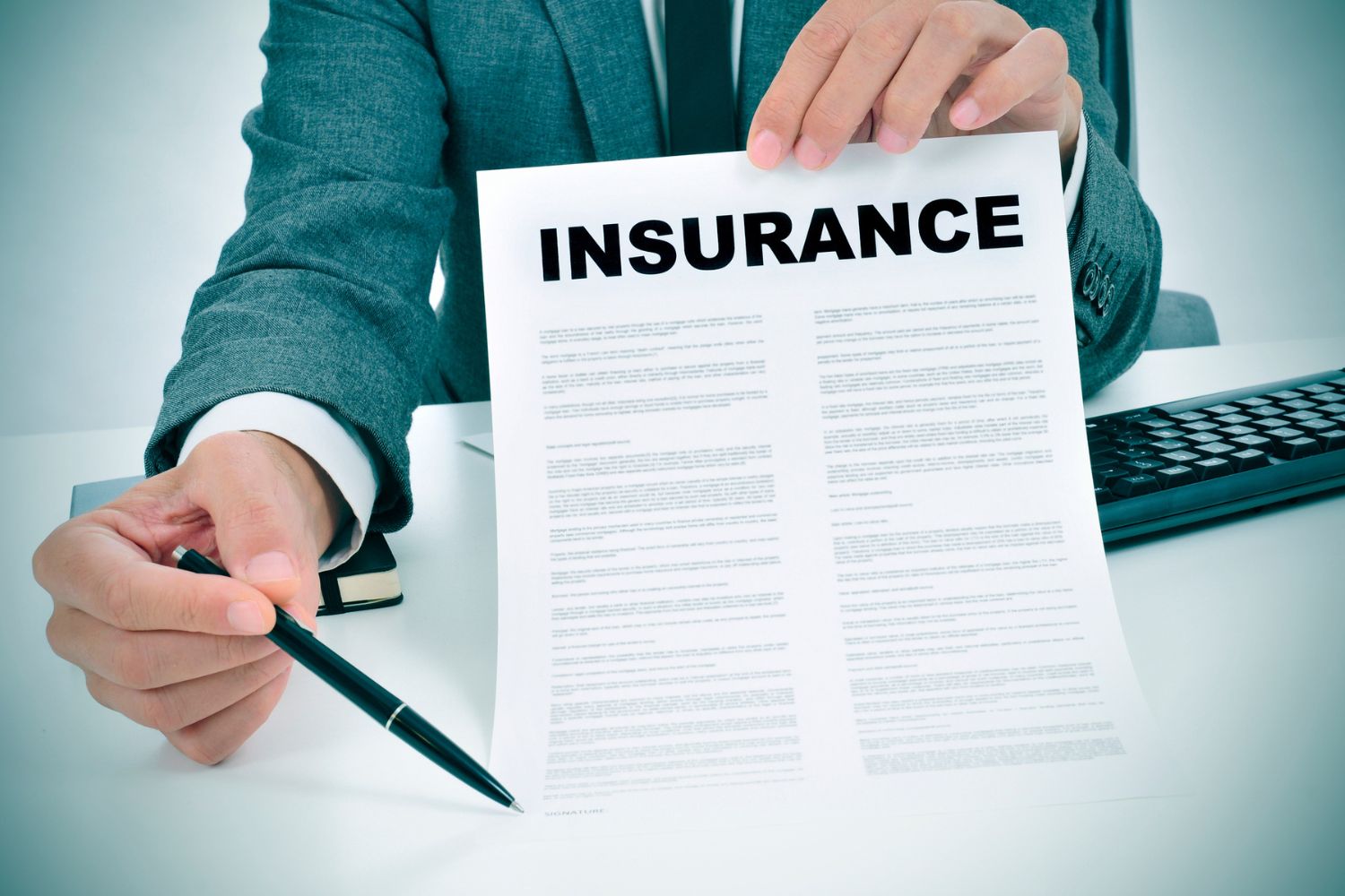 A closeup of a man in a suit holding a document called 'Insurance'.