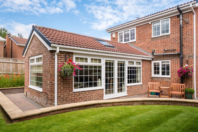 An exterior shot of a brick sunroom with a skylight.