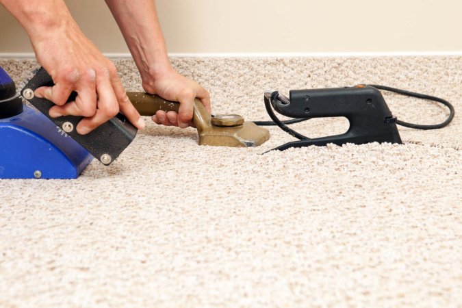 A close up of a person replacing carpet.