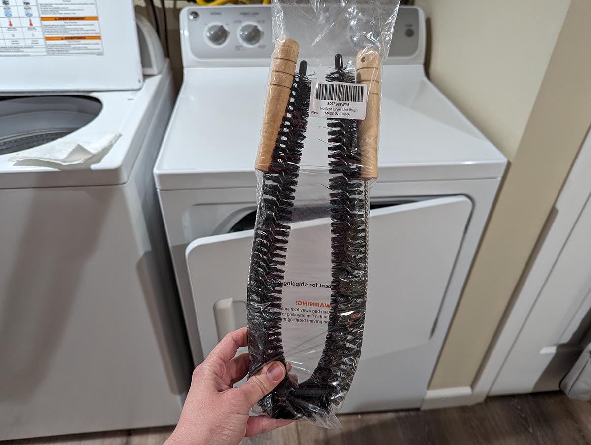 A person holding the Holikme 2-Pack Flexible Lint Brush Dryer Vent Cleaner before testing.