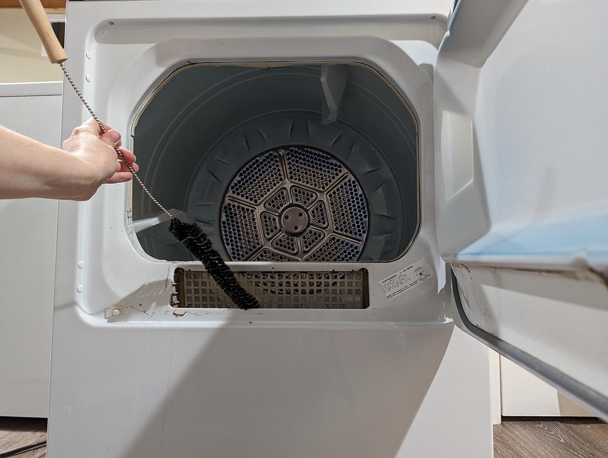 A person using the Holikme 2-Pack Flexible Lint Brush Dryer Vent Cleaner to clean their dryer during testing.