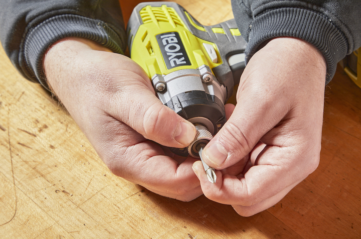 Pulling the chuck forward on an impact driver to seat the bit.