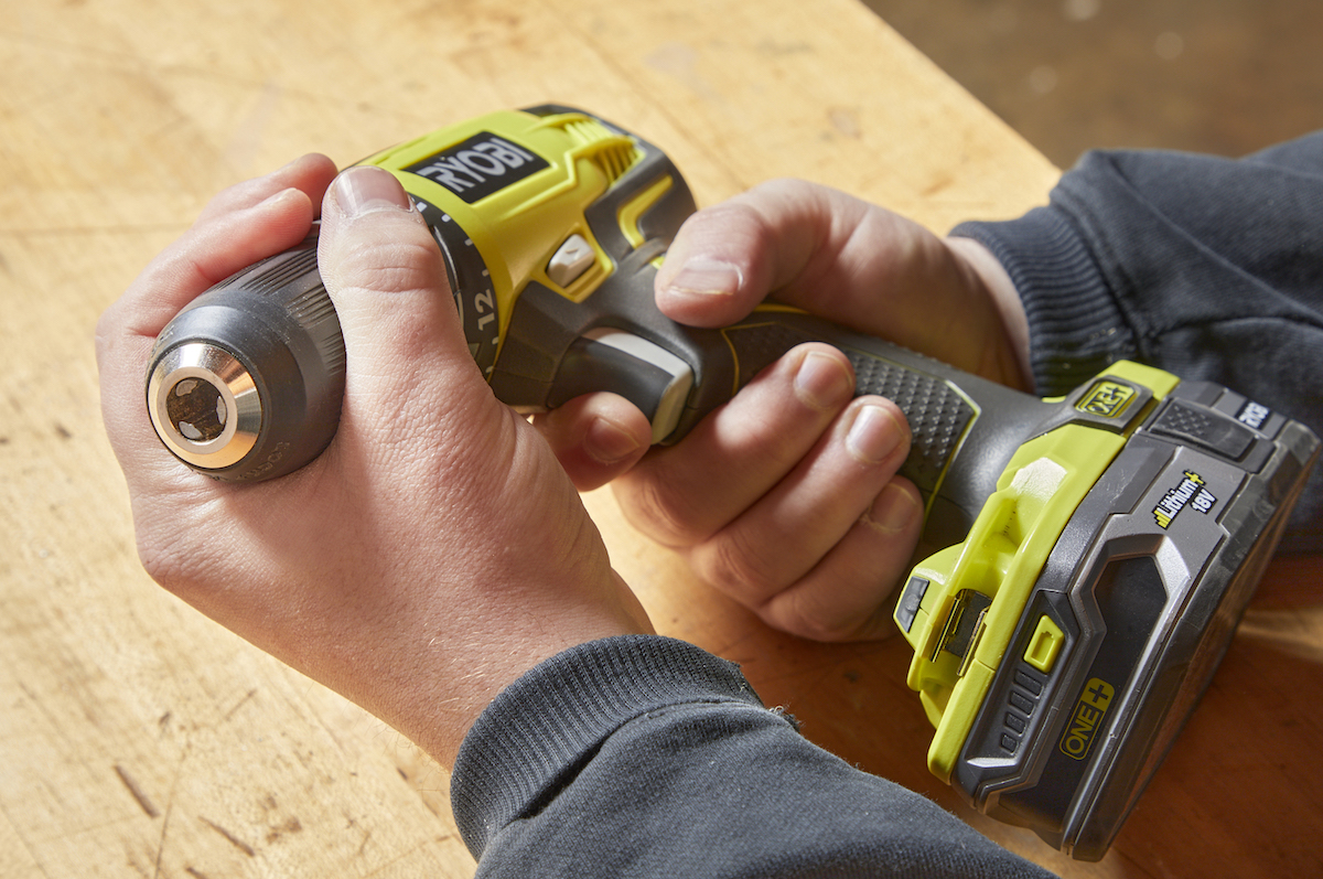 Handyperson squeezes the trigger on a cordless drill.