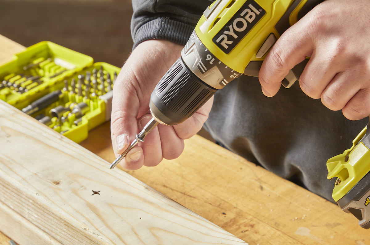 Man seats a drill bit into a screw.