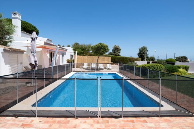 A rectangular inground pool with a mesh fence around the perimeter.