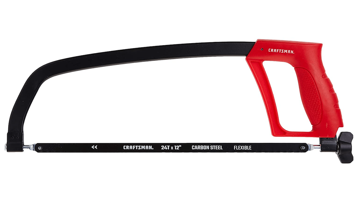 A red and black hacksaw resting in front of a white background. 