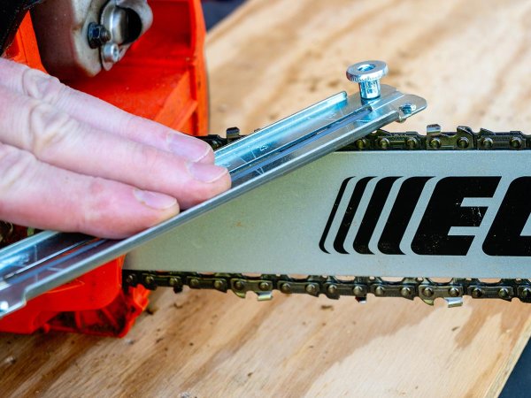 A person using the best chainsaw sharpener to sharpen a chain blade during testing.