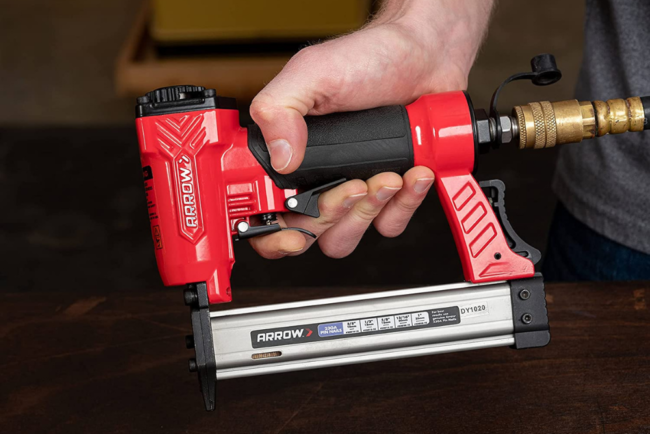 A person holding a pin nailer