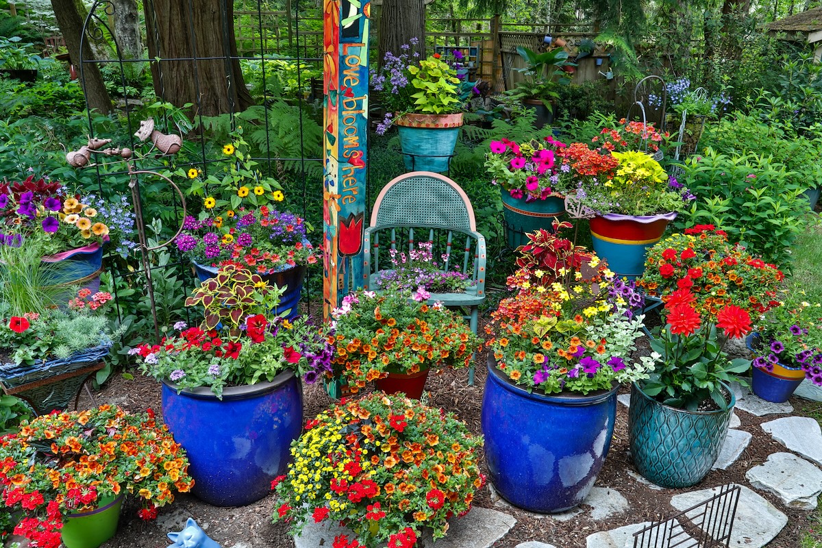 A flower pot compiled of unique flowers pots of various colors.