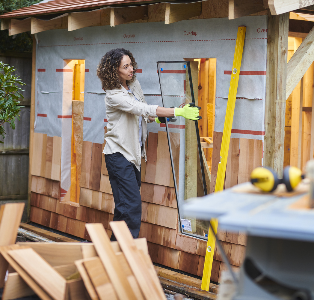 Woman finishing a partly built shed.