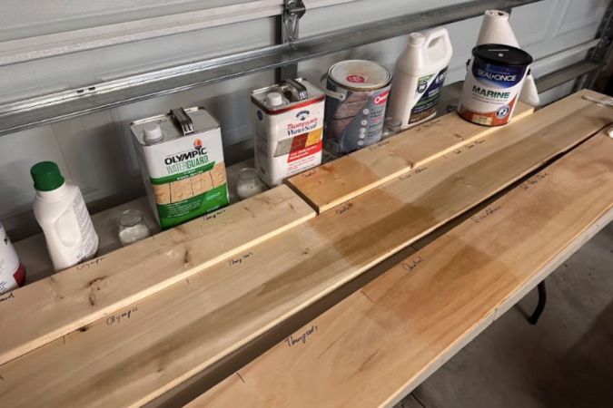 A lineup of the best outdoor wood sealers next to test boards.
