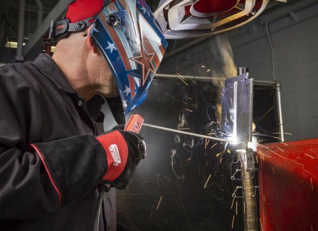 A person wearing a welding jacket while welding