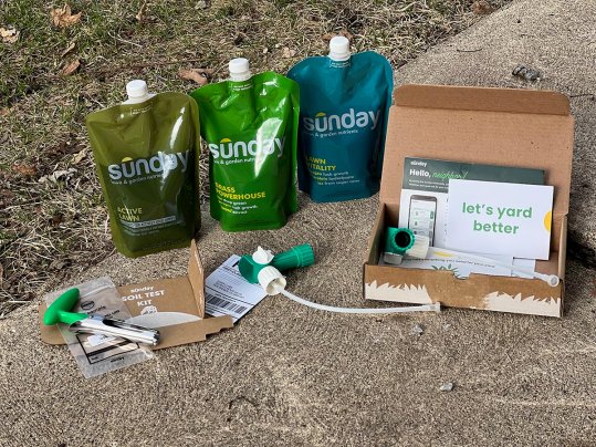 A Sunday lawn care kit is shown arranged on concrete.