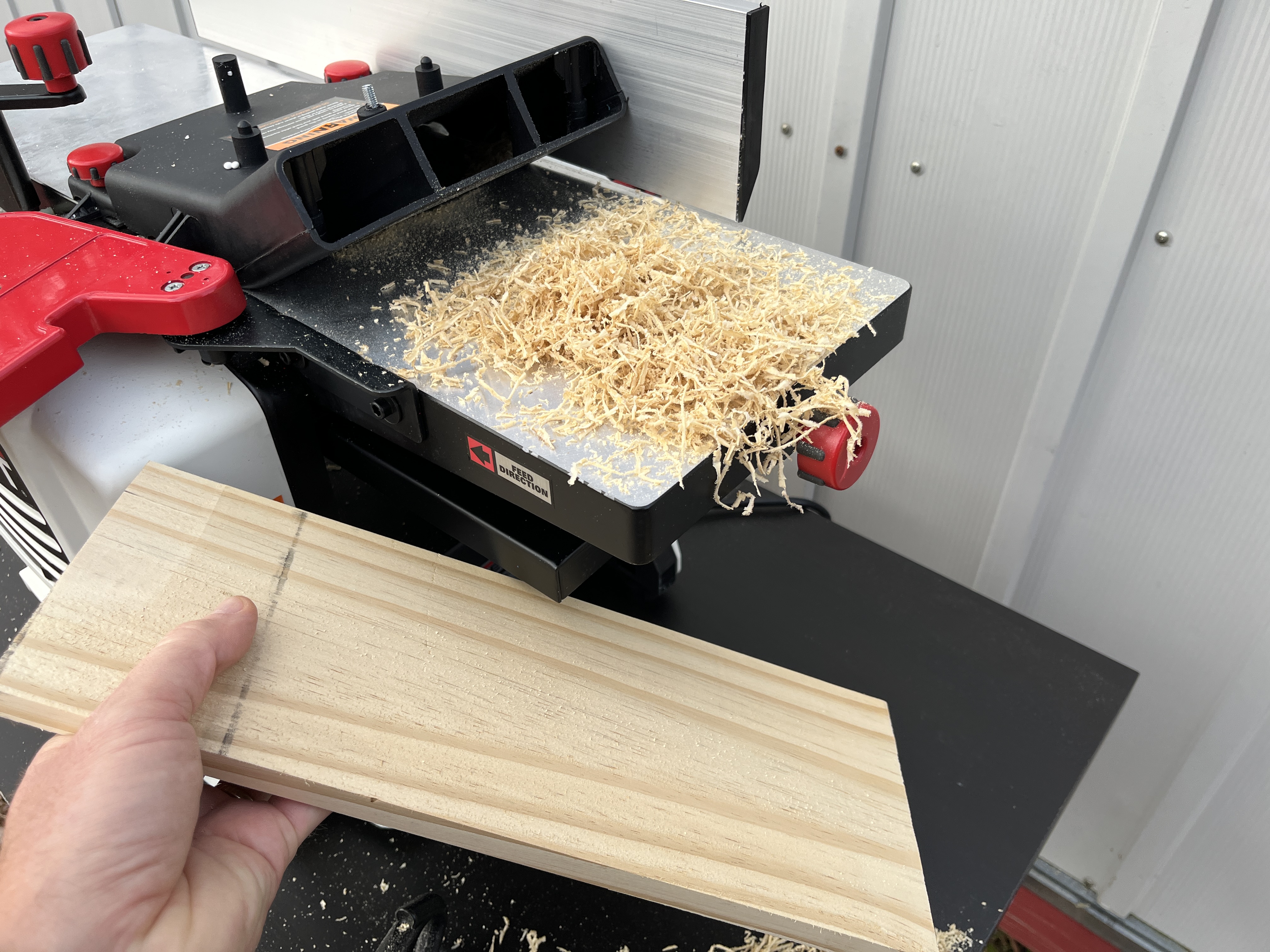 a man working with Jet jointer planer planing dust