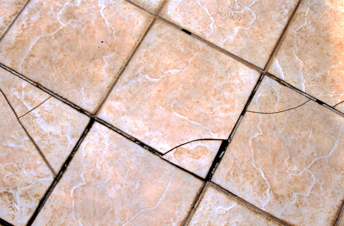 Cracked tan and grey floor tiles.