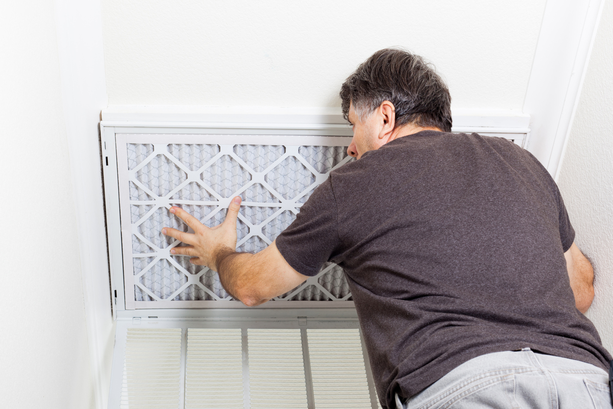 Man replaces an air filter overhead.