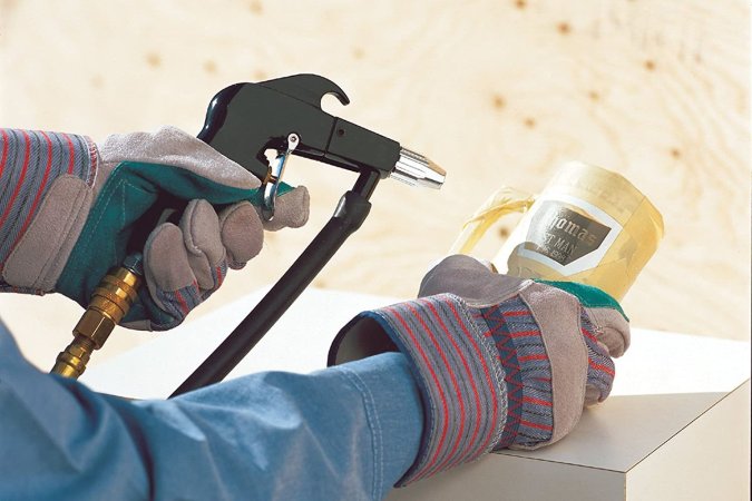 A person using the best sandblaster option to etch an inscription into a ceramic mug