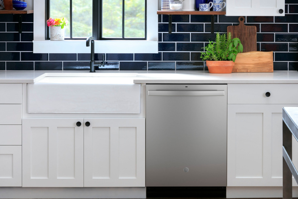 A GE dishwasher installed among white kitchen cabinets