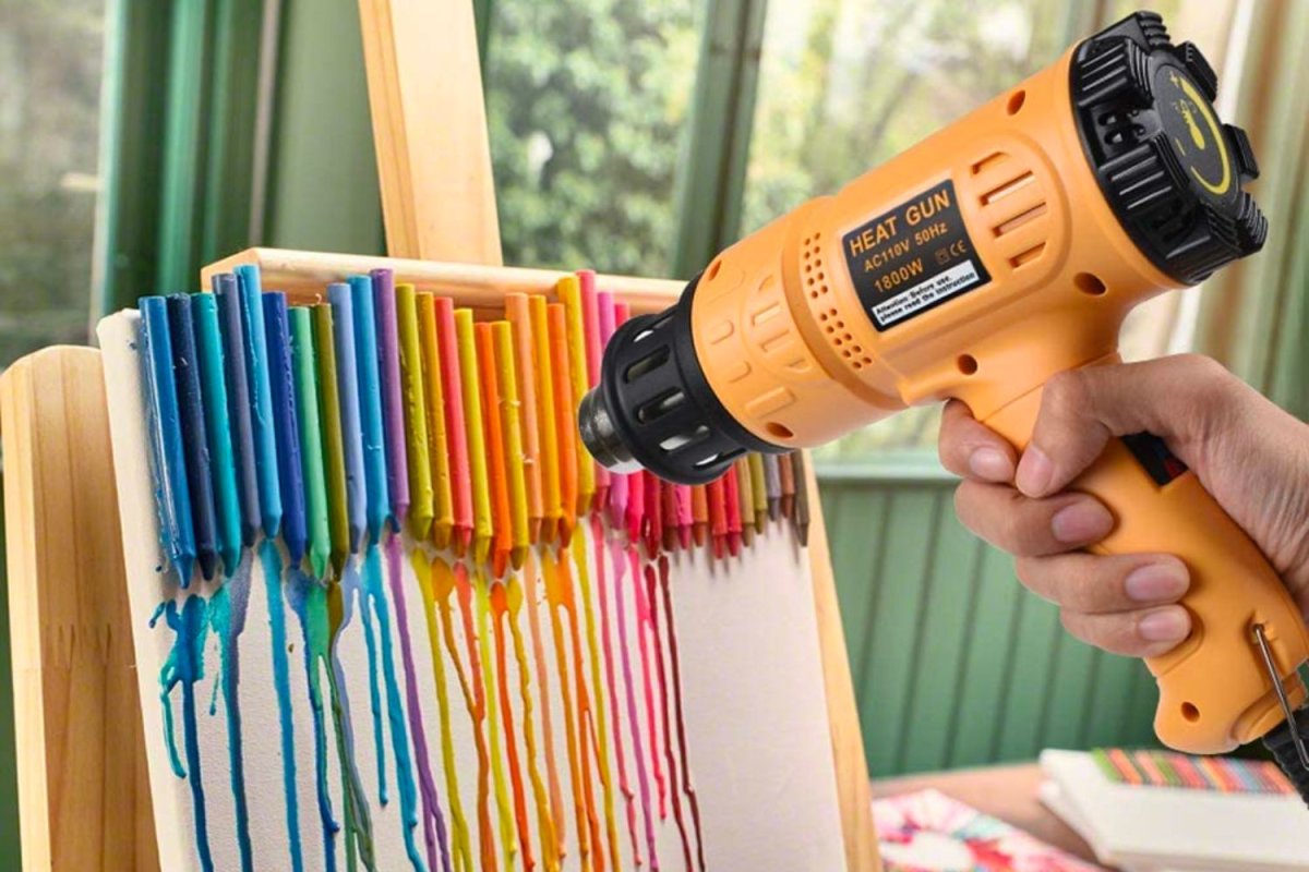 A person using a heat gun to melt crayons.