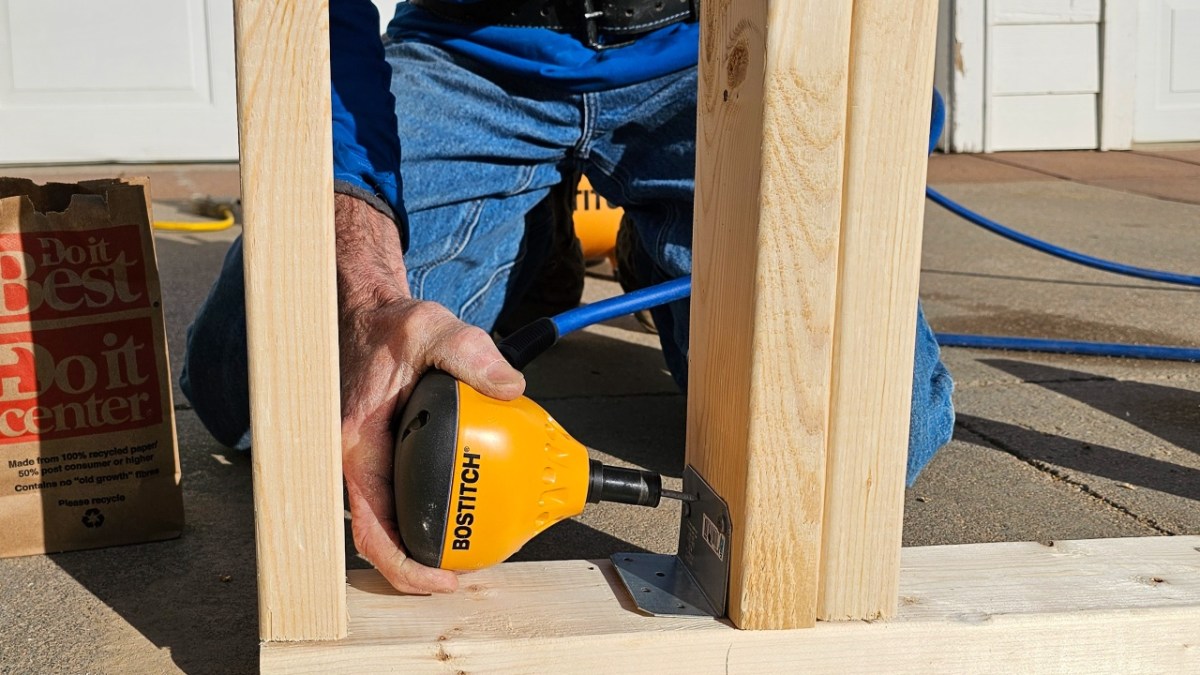 A person using the Bostitch palm nailer to install framing during testing.