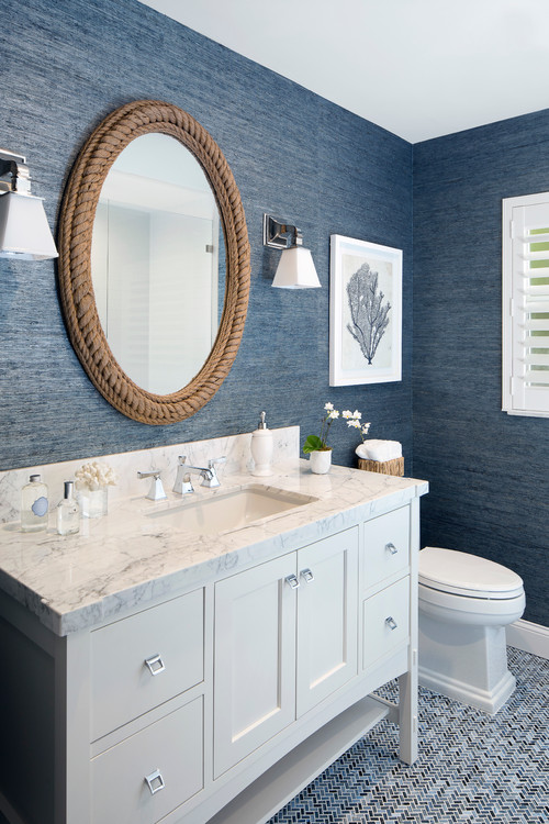 Oval-shaped bathroom mirror framed by a nautical rope facade