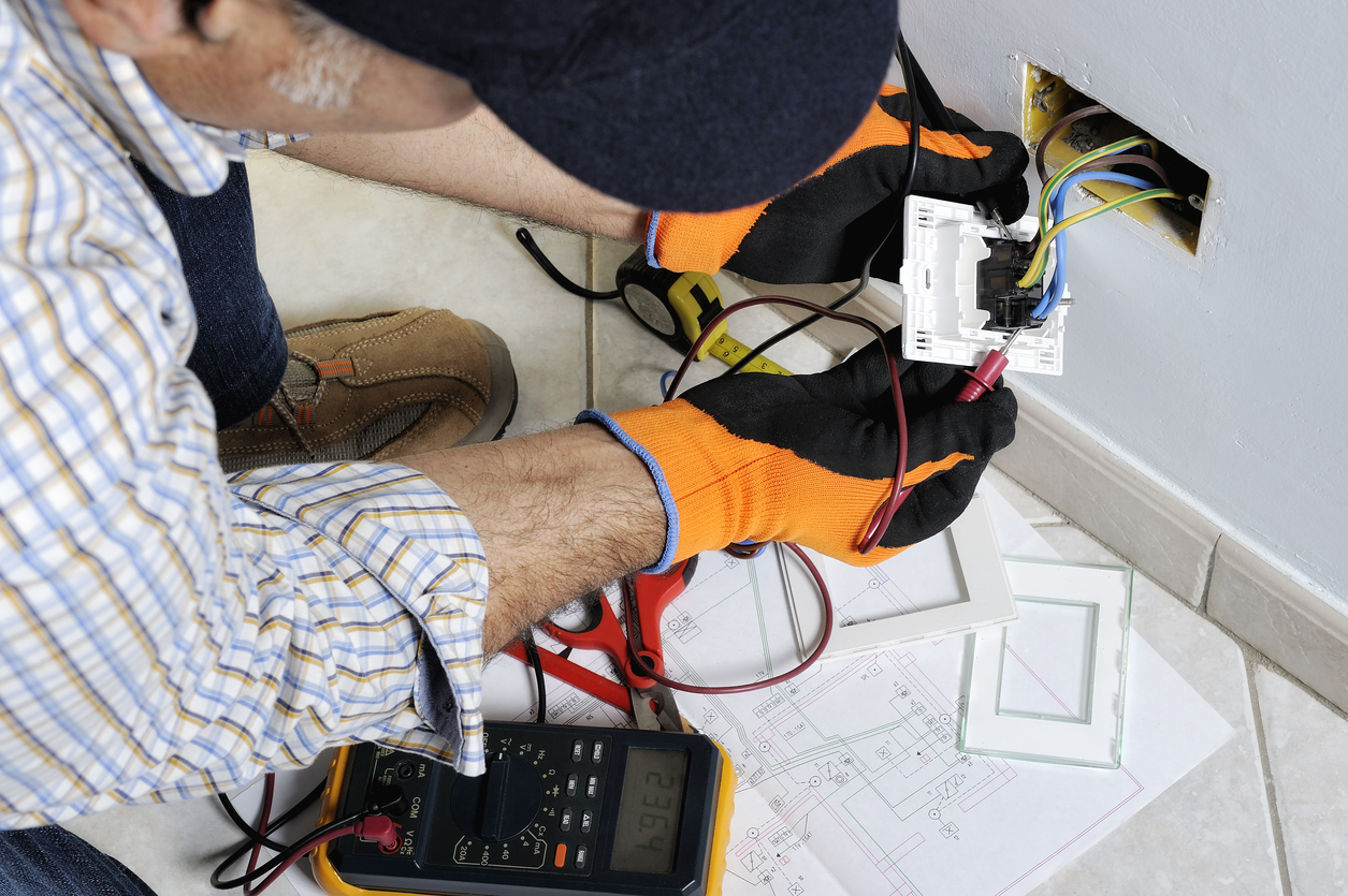 iStock-894986152 work gloves electrician working on outlet