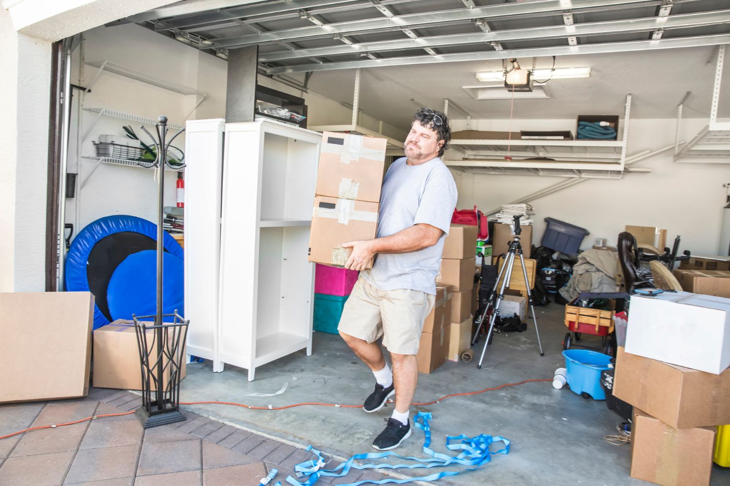 A man hauls boxes out of a garage.