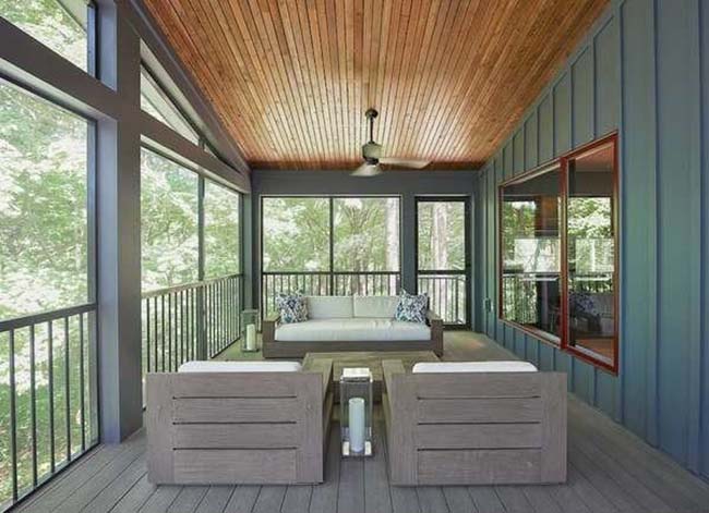 A home's porch with high wood-paneled ceilings, blue walls, and gray furniture.