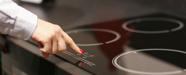 woman turning on a ceramic cooktop