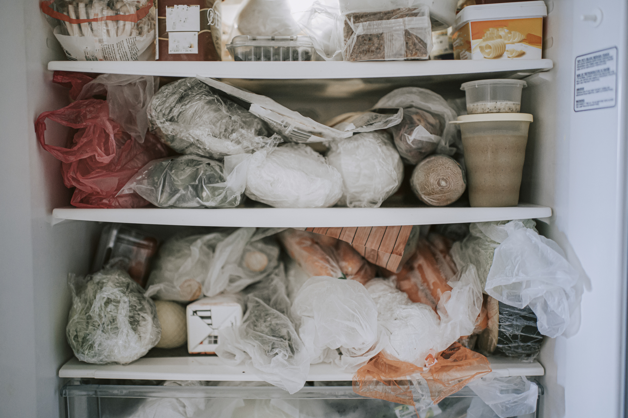 top freezer full of packages wrapped in plastic and freezer paper