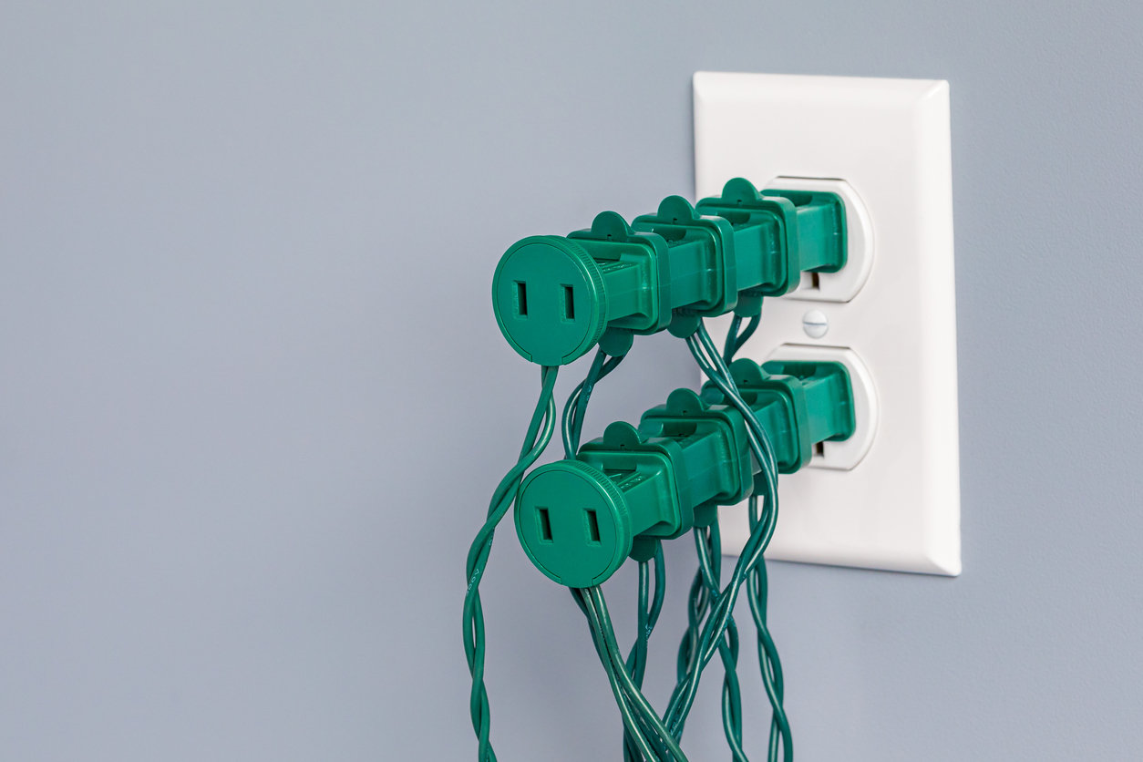 iStock-1356073058 Christmas tree care plug overloaded with Christmas light plugs