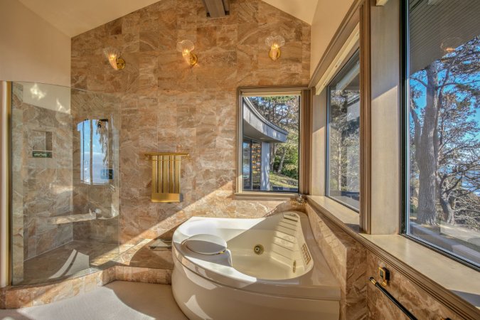 A tiled bathroom with a corner jetted tub.