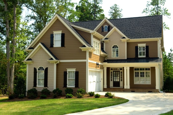 Brown and beige two-story suburban home with black shutters.