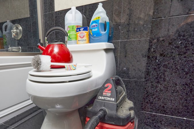 Materials used to unclog a toilet without a plunger, including a shop vac, tea kettle, dish soap, and more.