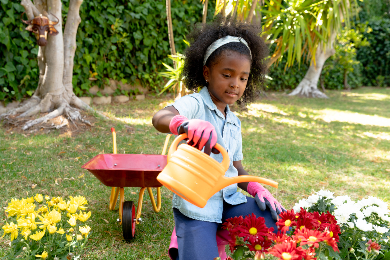 iStock-1226230243 cut flower garden young girl watering flowers.jpg