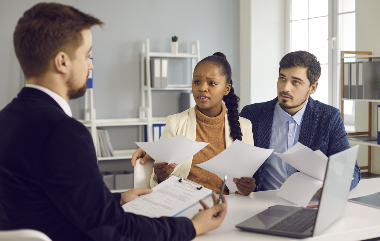 iStock-1329553958 inheriting a house couple meets with lawyer while reviewing documents