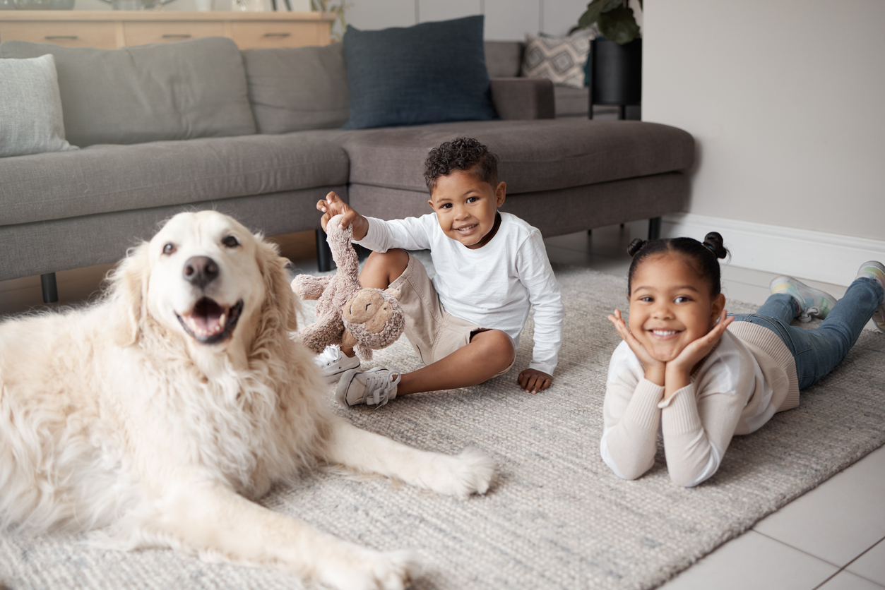 iStock-1402915209 get the funk out siblings playing with dog on carpet.jpg