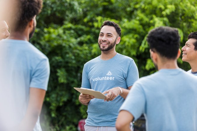 iStock-1411288734 volunteer opportunities young man talking to group of volunteers